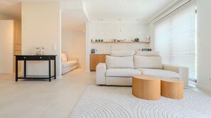 A modern living room with a sofa, coffee table, and a small side table. - Apartamenty Sun & Snow Kormoran (Świnoujście)