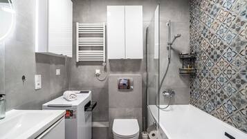A modern bathroom with a toilet, bidet, and shower.