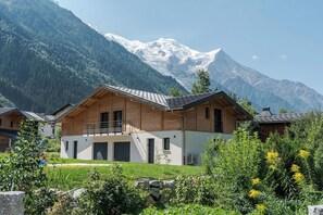 A wooden chalet with a balcony, set against a backdrop of snow-capped mountains. - Cimes - Cozy Apartment | 5 guests | Family-friendly | Quiet (Chamonix)