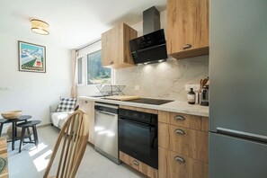 Une cuisine moderne avec des meubles en bois, un four noir et un micro-ondes encastré.