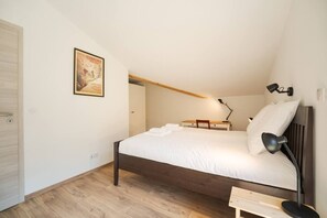 Ein Schlafzimmer mit einem Bett, einem Nachttisch, einer Lampe und einem Bild an der Wand.