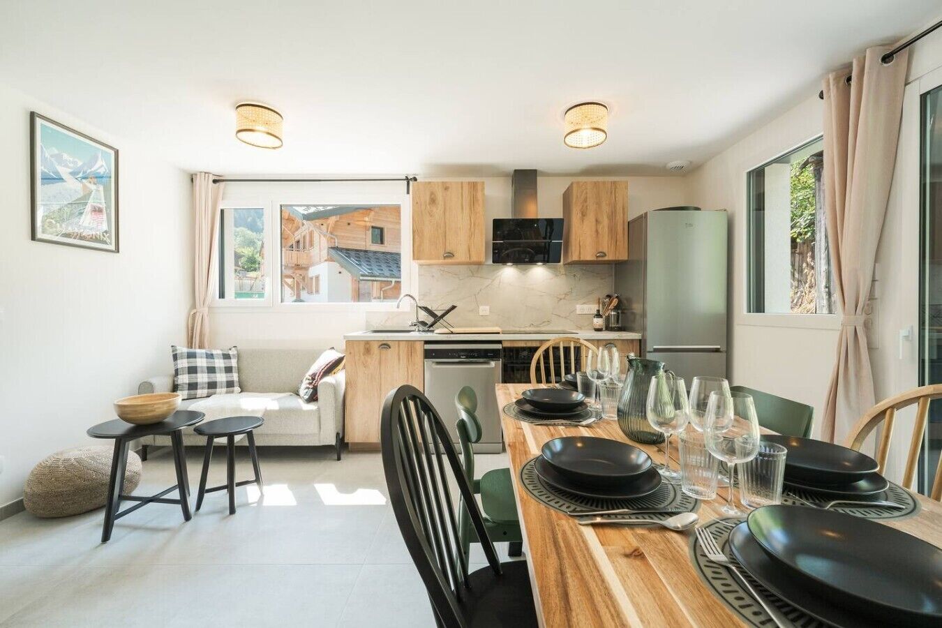 Une cuisine moderne avec des meubles en bois, une table à manger pour quatre personnes et une grande fenêtre qui laisse entrer la lumière naturelle.