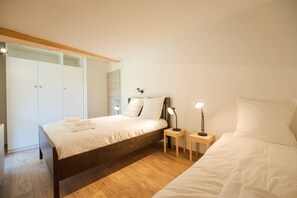 A bedroom with a bed, bedside tables, a wardrobe, and a mirror. - Cimes - Cozy Apartment | 5 guests | Family-friendly | Quiet (Chamonix)