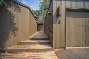 A wooden staircase leading to a garage with a number '3' sign. - Mid Century Modern with Sweeping Golf View (Sunriver)