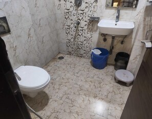 A bathroom with a toilet, sink, and shower.