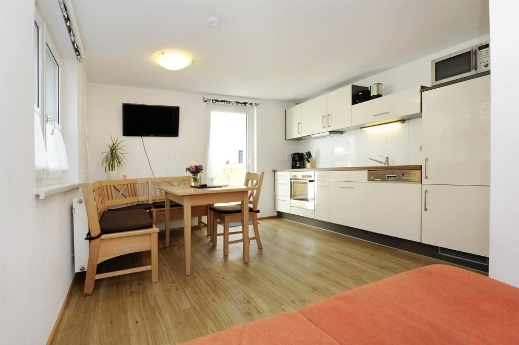 A compact kitchen with white cabinets, a microwave, and a coffee maker.
