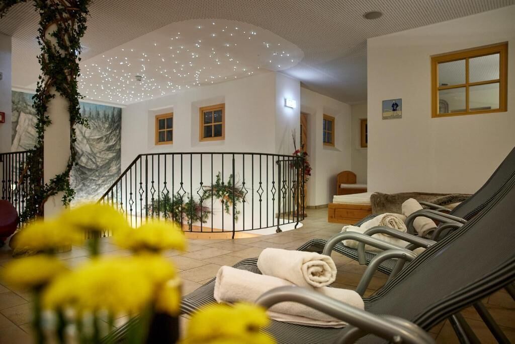 Un espace spa comprenant des fauteuils inclinables, une table de massage et un luminaire au plafond.