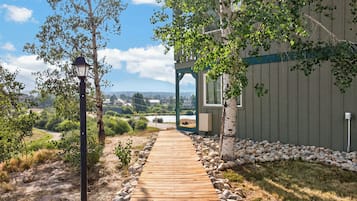 Un sendero de madera que conduce a un edificio con vistas a un lago y montañas.