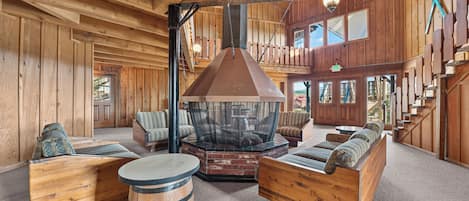 A rustic interior with wooden walls, a fireplace, and seating areas.