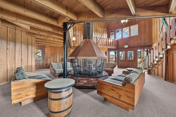 A rustic interior with wooden walls, a fireplace, and seating areas.