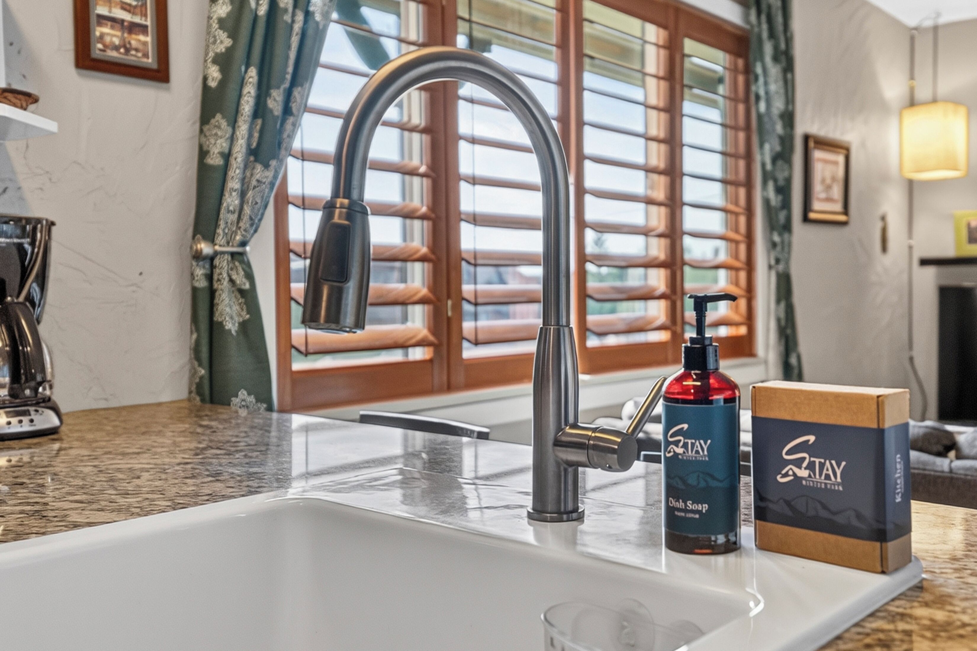 A kitchen with a modern faucet, a bottle of soap, and a box on the counter.