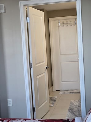 A hallway with two closed doors, a light switch, and a power outlet on the wall. - Stunning Arlington Condo with Balcony & Views Near Pentagon City (Arlington)