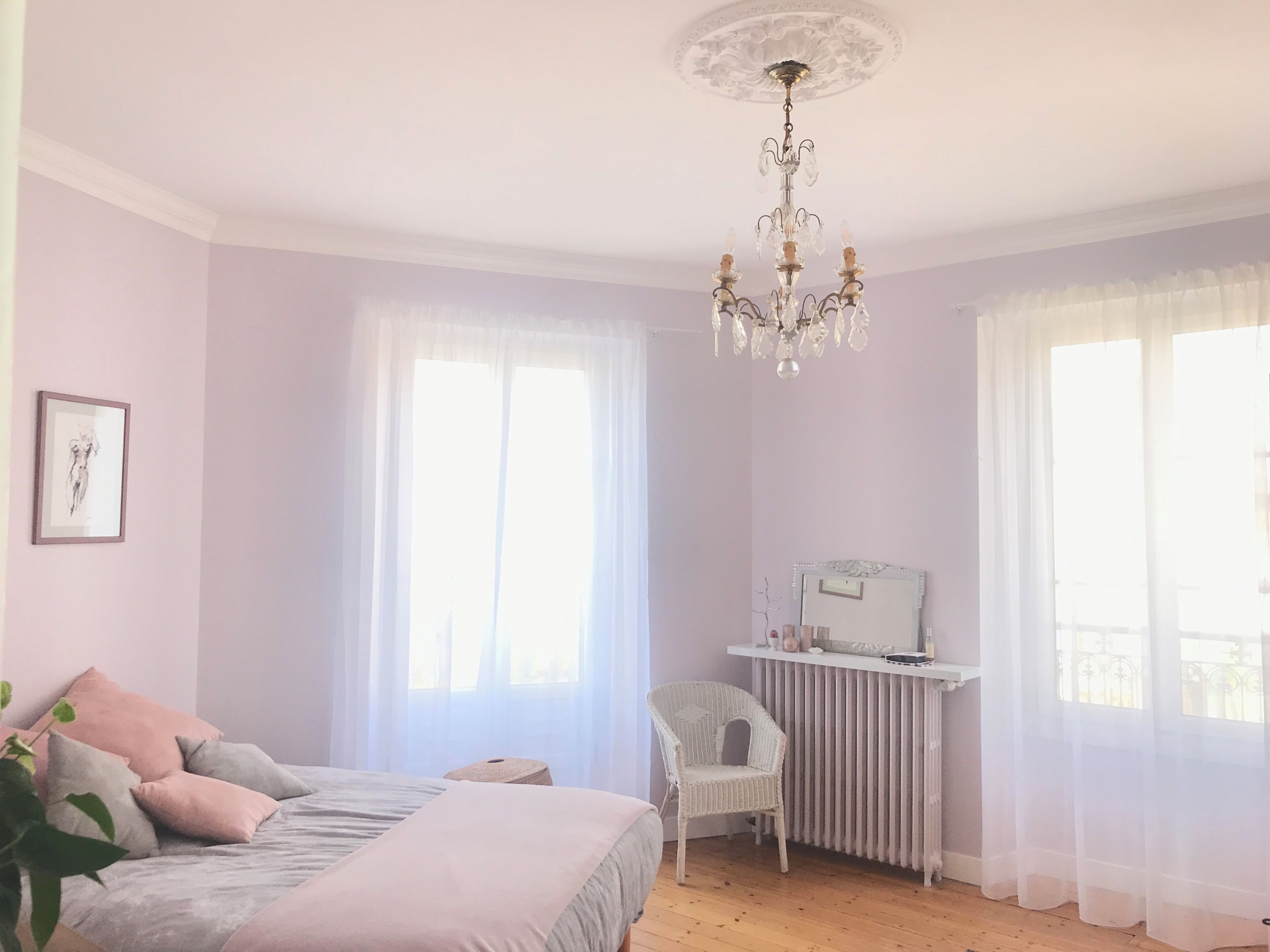 Une chambre à coucher avec un lit, une chaise, un bureau et un miroir.
