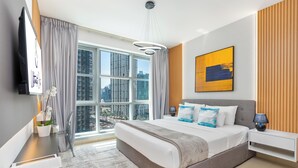 Una moderna camera d'albergo con un letto grande, vista sulla città, una TV a schermo piatto e un quadro appeso al muro.