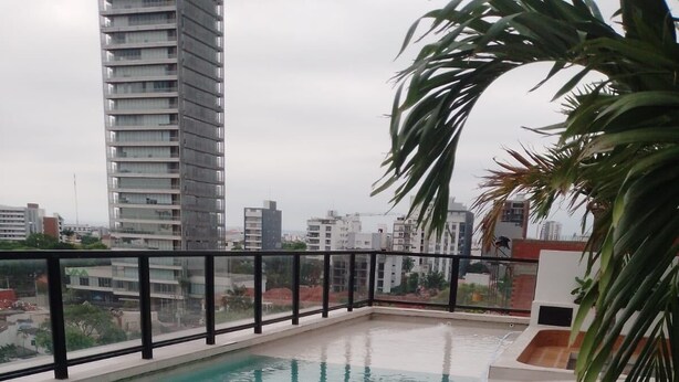 Una piscina en la azotea con vistas a edificios circundantes.