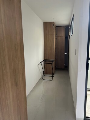 A narrow hallway with a wooden wardrobe, a metal rack, and a door leading to another room. - Cozy 1-bedroom studio in enchanting Santa Cruz de la Sierra with AC (Santa Cruz de la Sierra)