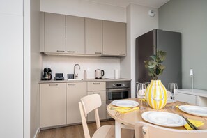 Una cocina moderna con comedor, equipada con cafetera, hervidor y un florero con plantas.