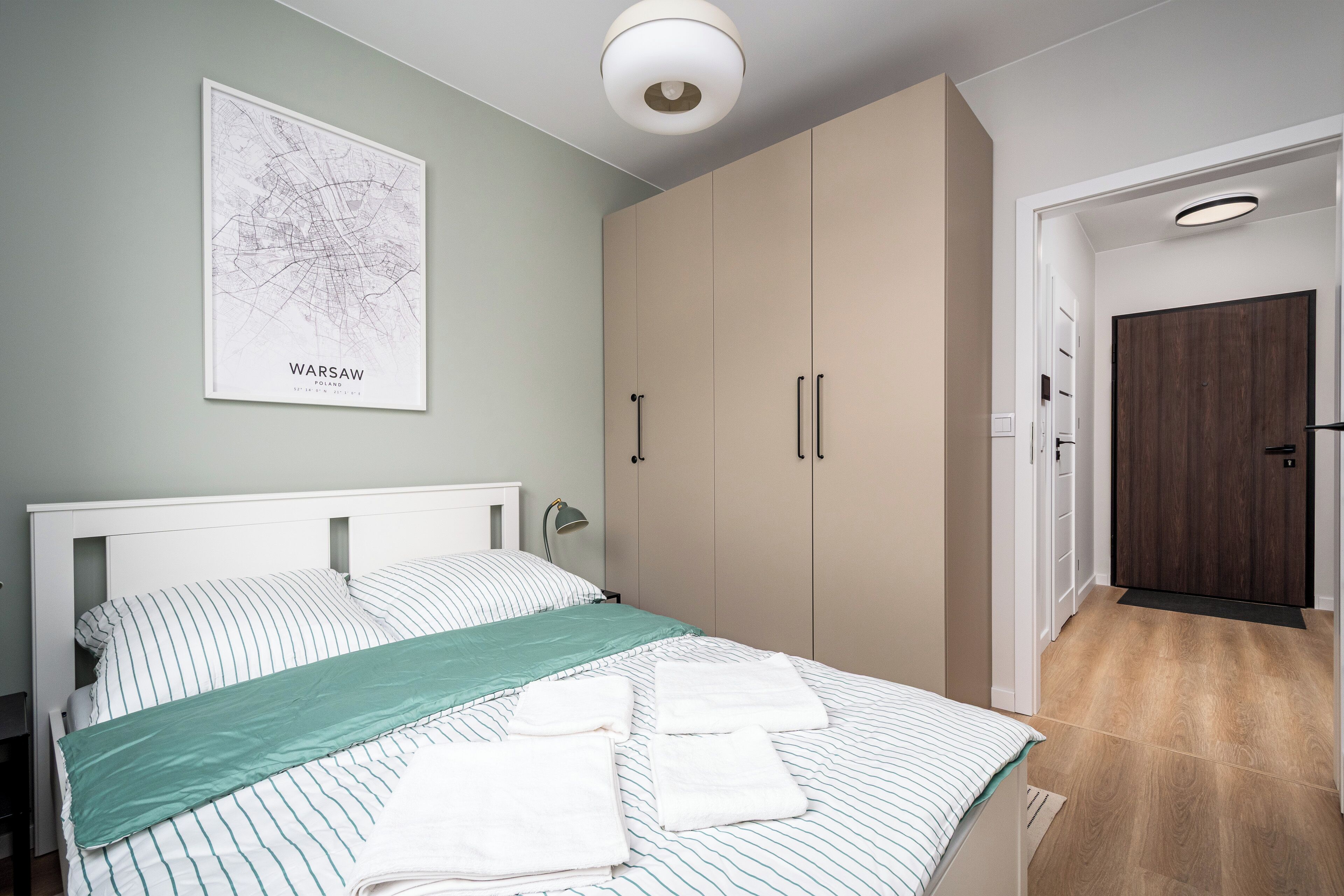 Ein Schlafzimmer mit einem Bett, einer Wandkarte und einem Kleiderschrank.