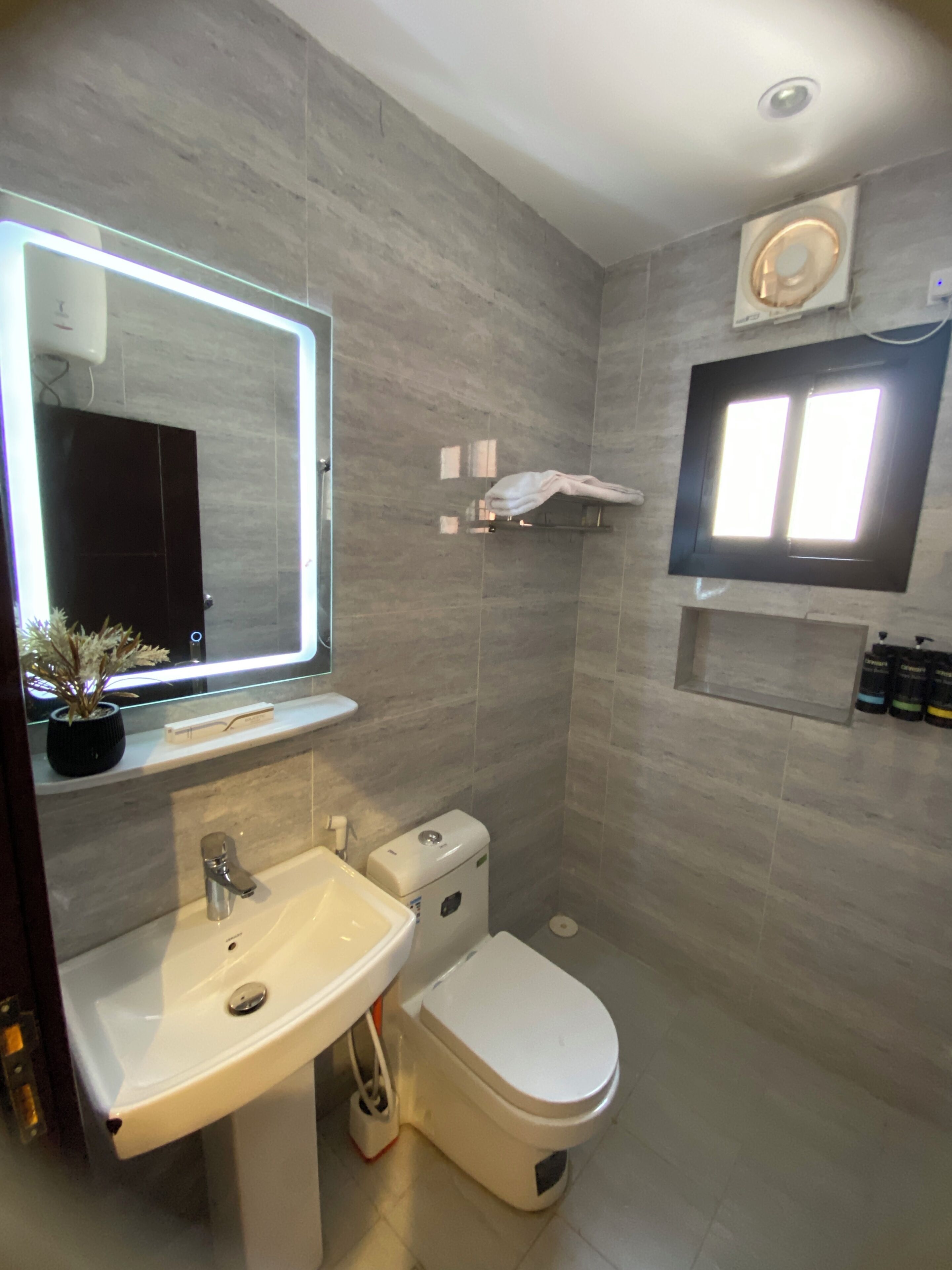 Un baño moderno con lavamanos, inodoro y espejo.