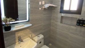 A modern bathroom with a sink, toilet, and mirror. - Studio Apartment in Al Hamdaniyah- J14 (Jeddah)