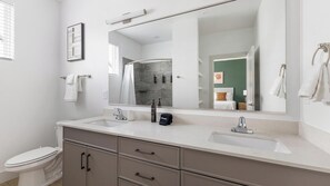 A modern bathroom with two sinks, a large mirror, and a toilet. - Landing Amazing 2bd, Courtyard, Pool (Dallas)