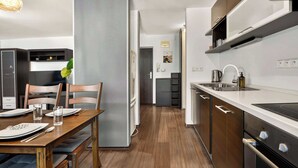 Eine moderne Küche mit Essbereich, ausgestattet mit Backofen, Spüle und Kühlschrank.