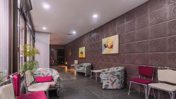 A lobby with patterned walls, seating areas, and artwork. - Apartamento no Guaruja com Vista para o Mar (Guarujá)