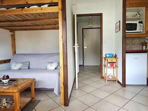 Ein Zimmer mit einem Etagenbett, einem kleinen Tisch mit einer Tasse, einer Mikrowelle und einem Kühlschrank.