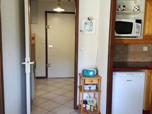 Eine Küche mit Mikrowelle, Kühlschrank und einer Speisekammer mit Küchenutensilien.