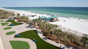 A beach resort with a pool area, a beach, and a lifeguard tower.
