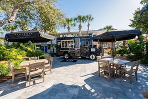 A food truck with a sign reading "VICTROLA Coffee Roasters Leatherwa" parked in front of a building labeled "NOMERL".