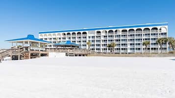 Ein großes Hotel mit mehreren Balkonen und einer Strandbar.