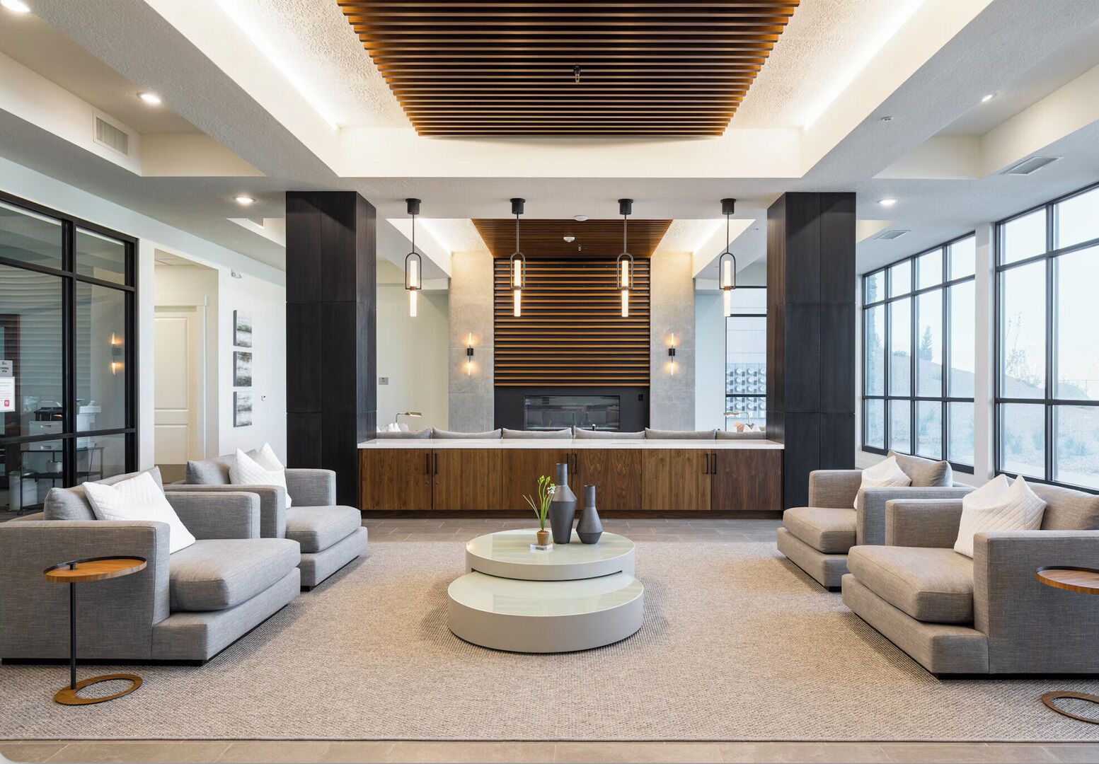 A modern living room with a central coffee table, sofas, and a fireplace.