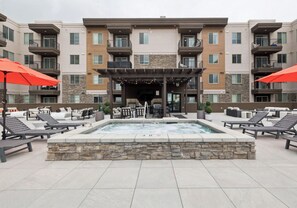 A rooftop pool area with lounge chairs, a hot tub, and outdoor seating. - Landing Modern 1bd, Gym (Draper)