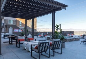 An outdoor patio area with seating arrangements, a pool, and a view of mountains. - Landing Modern 1bd, Gym (Draper)