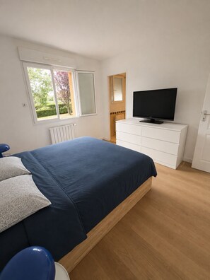 A bedroom with a bed, a dresser, a television, and a window. -  Villa Émeraude • 4 bedrooms • Garden • Beaches within 1 km • Saint-Malo, 5 km (Saint-Coulomb)