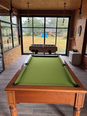 A pool table with a green felt surface, wooden legs, and a wooden table top. - Renovated Old Norman Stable (Luneray)