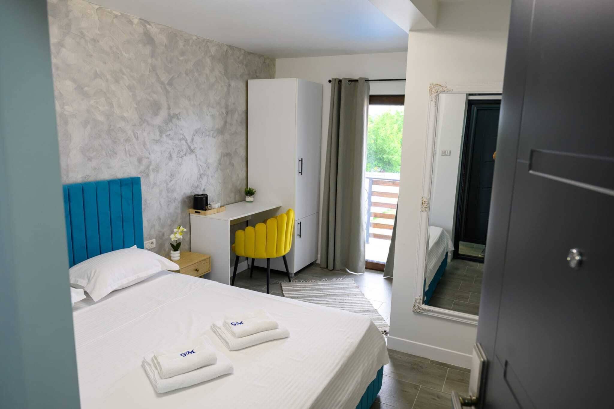 Une chambre d’hôtel avec un lit, un bureau, une chaise et une armoire.