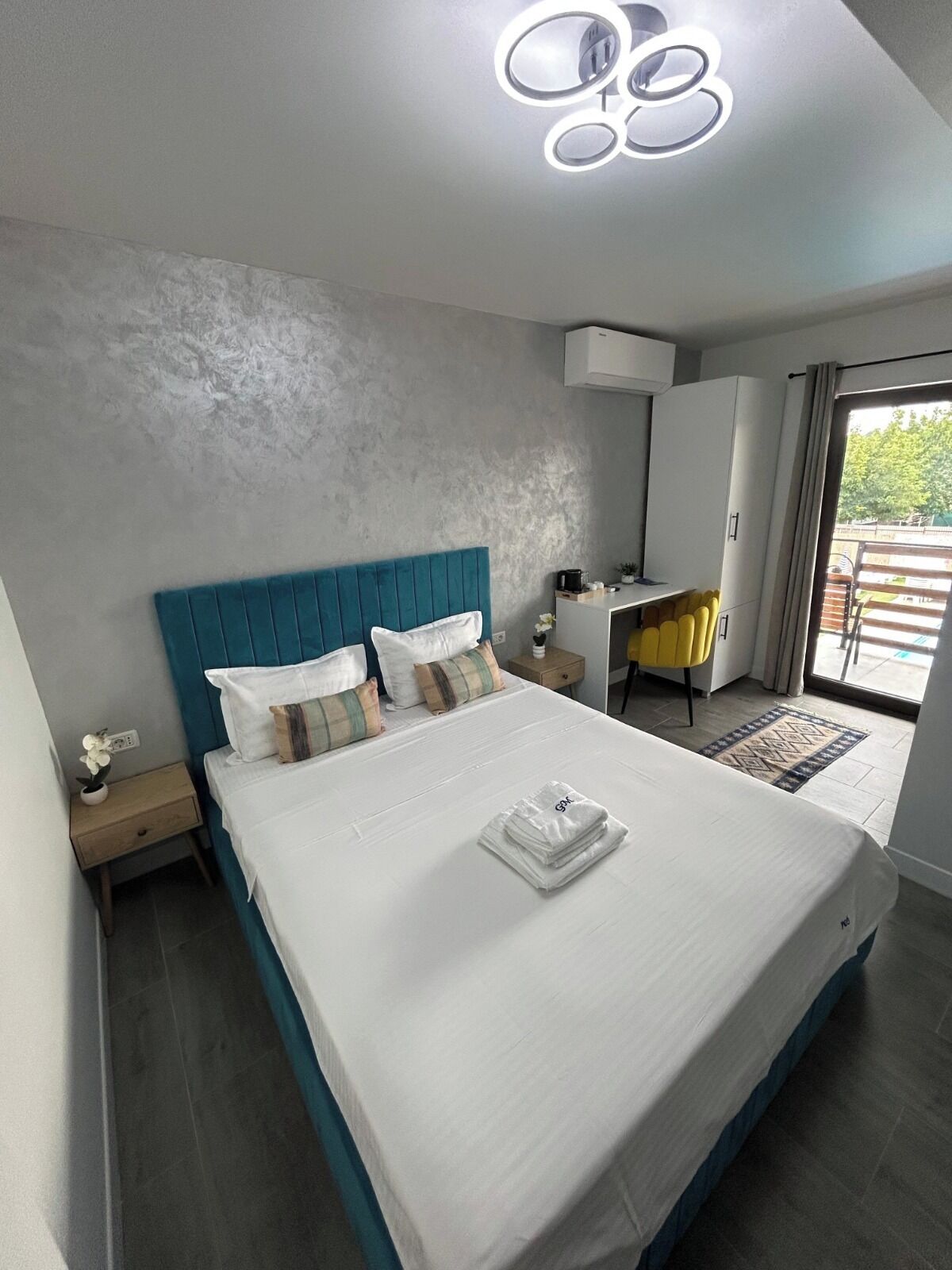 Un dormitorio moderno con una cama grande, un escritorio y vistas al exterior.
