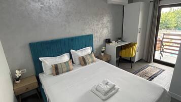 Un dormitorio moderno con una cama grande, un escritorio y vistas al exterior.