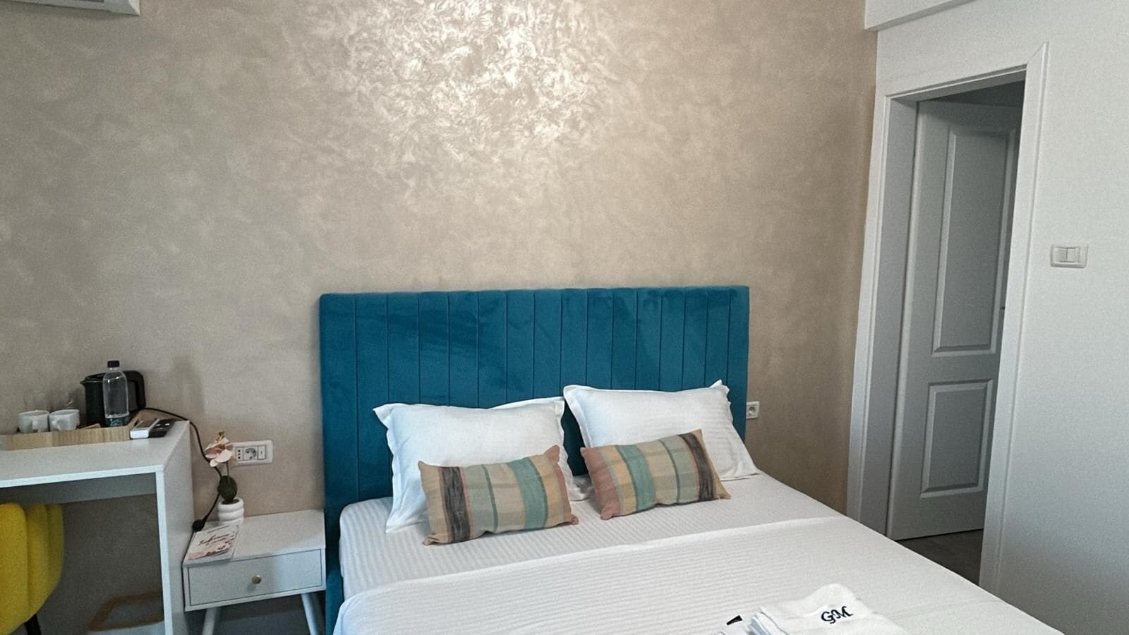 Una habitación de hotel con una cama, un escritorio y una silla.
