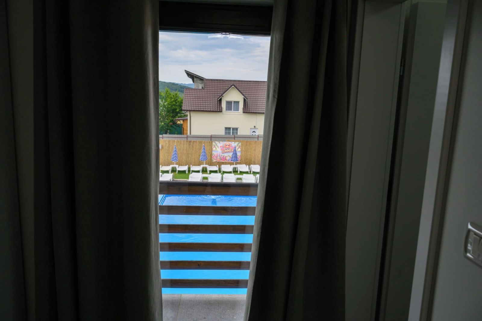 A view through a doorway to a pool area with a building in the background.