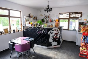 A bar area with a counter, bar stools, and a wall mural. - Good Mood Pool & Smart Rooms (Ciurea)