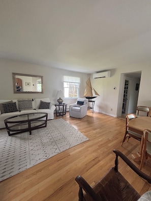 A spacious living room with a sofa, coffee table, and a sailboat model.