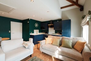 A modern kitchen with dark blue cabinets, a white countertop, and a built-in oven. - Chic 1BR Flat with Parking-Easy access to City Center (Leeds)
