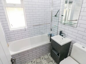 A bathroom with a bathtub, a sink, a toilet, and a glass shower enclosure. - Pleasant Valley Holiday Lodge 70 (Narberth)
