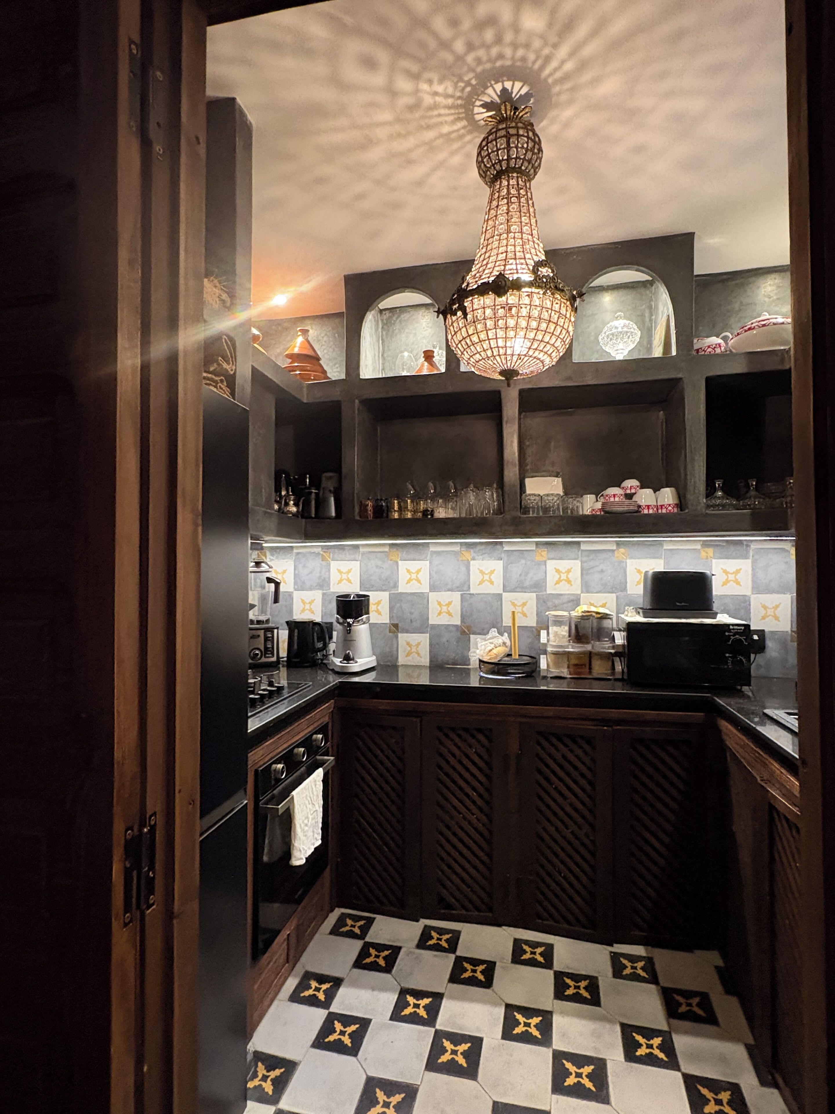 Una cocina con piso de tablones, una máquina de café y un microondas.