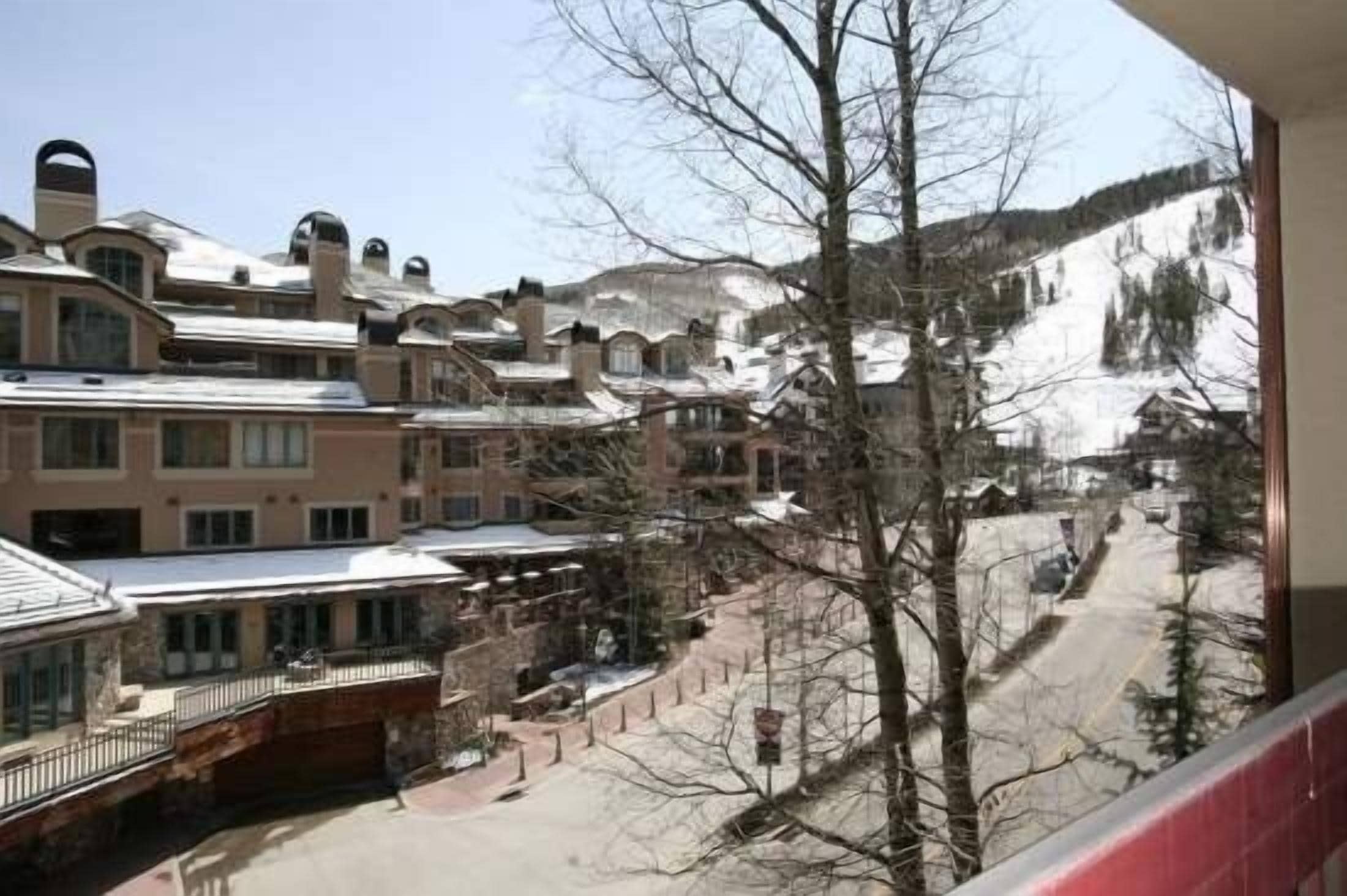 A hotel with multiple buildings, a snow-covered mountain in the background, and a clear sky.