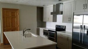 A kitchen with a central island, stainless steel appliances, and light-colored cabinetry. - Strawberry Park Condos With Easy Ski-in Ski-out Access Steps Away From Center Of Beaver Creek Village 1 Bedroom Condo (Avon)