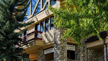 Un edificio de varios pisos con fachada de piedra, balcones y un letrero que dice 'Vail Realty'.